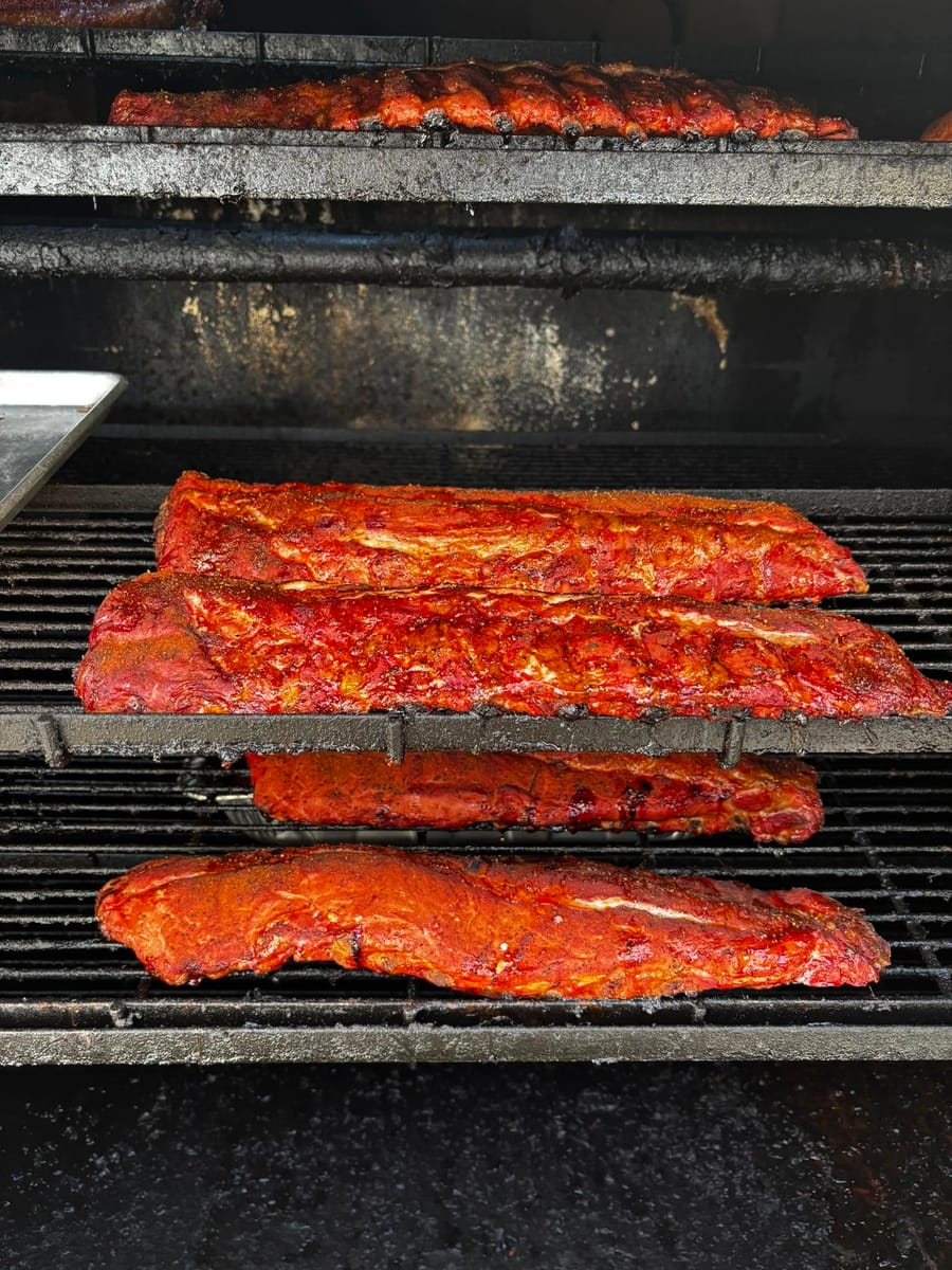 Racks of ribs and pork loin on the smoker grates